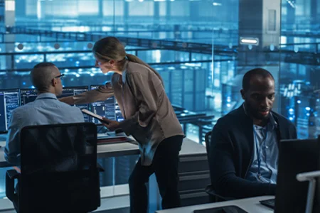 IT security consultancy: identifying risks, strengthening security Symbolic image: A team of experts analysing IT systems on monitors in a control room.