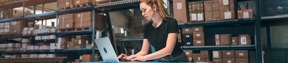 Cloud-ERP-Systeme – geräte- und ortsunabhängig einsetzbar Mitarbeiterin in der Logistik arbeitet mit ERP-System am Laptop zur Lagerbestandsverwaltung.