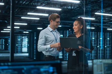 GOB’s digitalisation consultancy – Identifying opportunities and shaping change Illustrative image: Two consultants with laptop by server racks for GOB digitalisation consultancy.